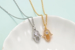 Micro-pave Hamsa hand necklaces with zircon stones in gold and silver finish