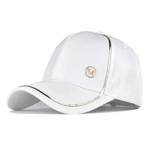 Detail of white baseball cap showing gold piping, metallic M badge and silky texture