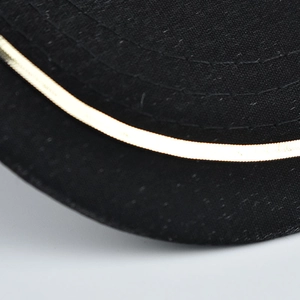 Detailed close-up of the black fabric stitching and golden trim on a baseball cap