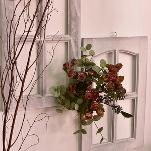 Vintage silk rose bouquet with eucalyptus leaves against a rustic window frame backdrop