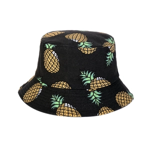 Detailed view of black canvas bucket hat with yellow pineapple prints and stitching