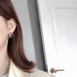 Detail view of a model wearing minimalist silver S925 multilayer C-shape hoop earrings