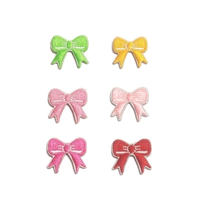 Set of six colorful bow embroidery patches in various colors on white background