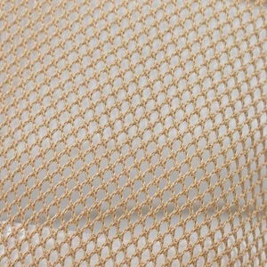 Close-up macro view of the breathable tan mesh fabric on a summer fedora sun hat