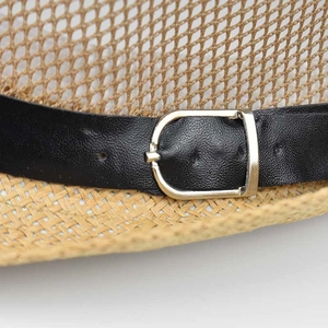 Detailed macro view of woven flax texture and black leather band with silver metal buckle