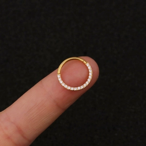 Close-up of gold stainless steel hinged ring earring with pave clear zircon stones