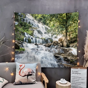 Forest waterfall tapestry hanging on a grey wall with warm starry fairy lights