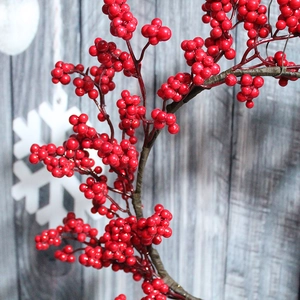 Artificial red berry branches for Christmas decor with winter snowy background