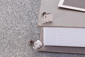 Detailed view of silver elephant stud earrings with zircon eyes on a glittery background
