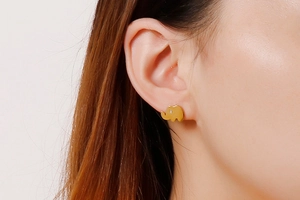 Close-up of a model wearing a cute gold elephant stud earring with a sparkling zircon eye