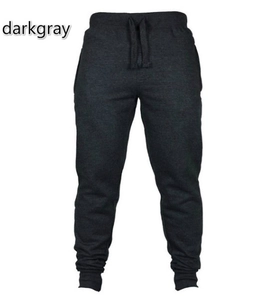 Detail of dark gray jogger pants featuring an elastic drawstring waist and ribbed cuffs