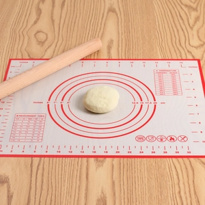 Non-stick platinum silicone pastry mat with measurement scales on a wooden tabletop