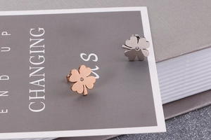 Macro view of clover-shaped titanium steel studs with rose gold and silver finish