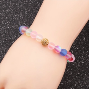 Bracelet en perles de pierre de lune mates avec accent en strass or rose sur poignet