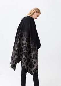 Detail showing high-density knitted leopard print fabric texture on a fashion poncho