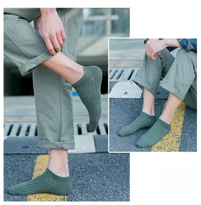 Close-up of dark green vertical striped cotton low-cut ankle socks for men