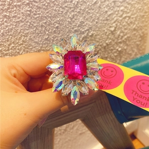 Macro view of crystal flower phone grip featuring a large rose red gemstone and AB rhinestones
