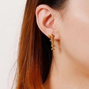Gold abstract fish heartbeat stainless steel drop earrings shown worn on female model