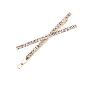 Elegant gold rhinestone hair clip with cross design on a clean white background