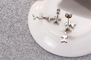 Macro shot of silver fish-shaped pulse line earrings made of stainless steel