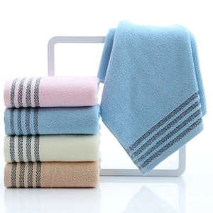 Gros plan de serviettes en coton avec motif ondulé et bordure à rayures grises