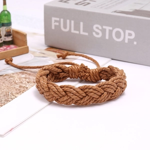 Detail view of brown braided hemp rope bracelet with adjustable knot and fiber texture