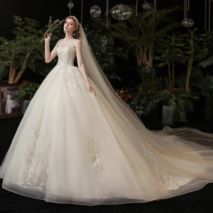Ivory bridal ball gown with intricate lace embroidery and a grand cathedral train