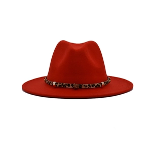 Detailed macro view of the leopard print band and golden star rivets on the red wool fedora