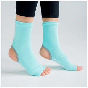 Detail of light blue toeless yoga socks with anti-slip white dots on heel and sole