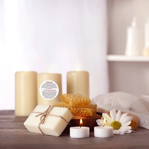 Natural pillar candles set with safety warning labels and handmade soap on wood