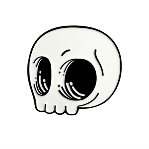 Detailed close-up of a skull-shaped enamel pin with white and black finish for Halloween