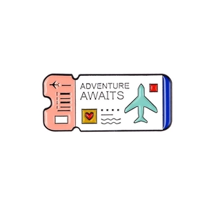 Detailed view of airplane ticket enamel pin with Adventure Awaits text and pink heart