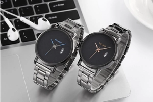 Macro detail of YOLAKO quartz watch with black dial and grey metal mesh band on a keyboard