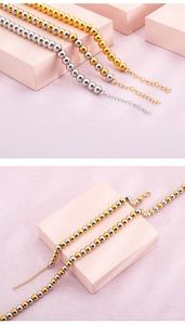 Detailed view of bead necklaces in gold, silver, and dual-tone steel on pink podiums