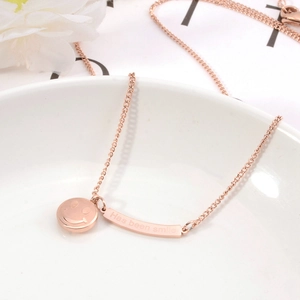 Dettaglio collana in oro rosa 18K con ciondolo sorriso inciso su piatto bianco