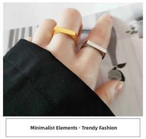 Detail of minimalist rectangular geometric open rings in gold and silver finishes