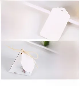 Close-up of vintage scalloped white paper tags and marble pattern pyramid gift boxes