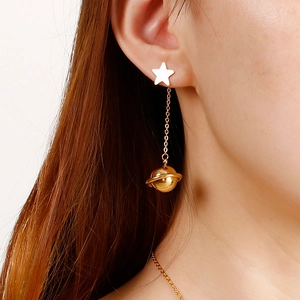 Star and planet gold pendant earrings on model with minimalist stainless steel chain