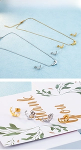 Detailansicht der Hirschgeweih-Halskette und Ohrringe in Gold und Silber auf Karten