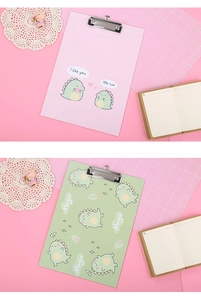 Detail of A4 clipboards featuring cute cartoon dinosaur prints and metal clamps