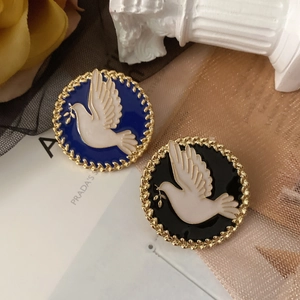 Detail of vintage enamel dove brooches in navy and black with gold woven edges
