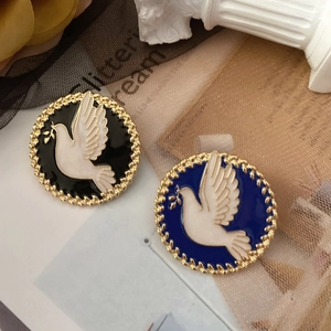 Detailed macro view of vintage peace dove enamel pins with gold frames on rose petals