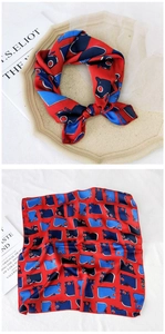 Detailed view of red and blue printed silk scarf with geometric and animal patterns