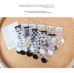Detailed view of five pairs of ultra-thin jacquard sheer socks with patterns on bamboo tray