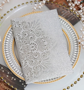 Detailed view of silver glitter hollowed out wedding invitation with mandala pattern