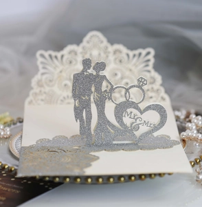 Detail of laser-cut wedding invitation with silver glitter 3D Mr & Mrs pop-up and rings