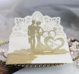 Macro shot of 3D gold glitter laser-cut wedding card featuring Mr & Mrs heart and rings