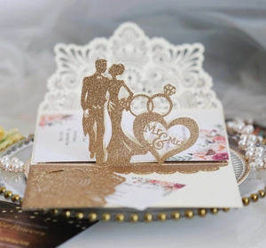 Macro detail of laser-cut glitter wedding invitation with 3D Mr & Mrs pop-up design