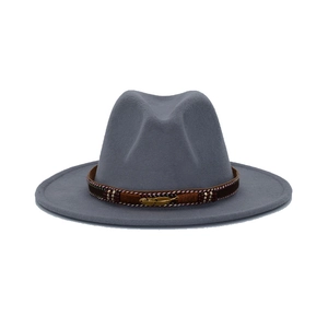 Close-up of wide brim fedora hat with ethnic band and vintage gold feather ornament
