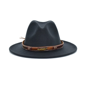 Detailed texture of dark grey wool felt fedora with a bronze feather charm band
